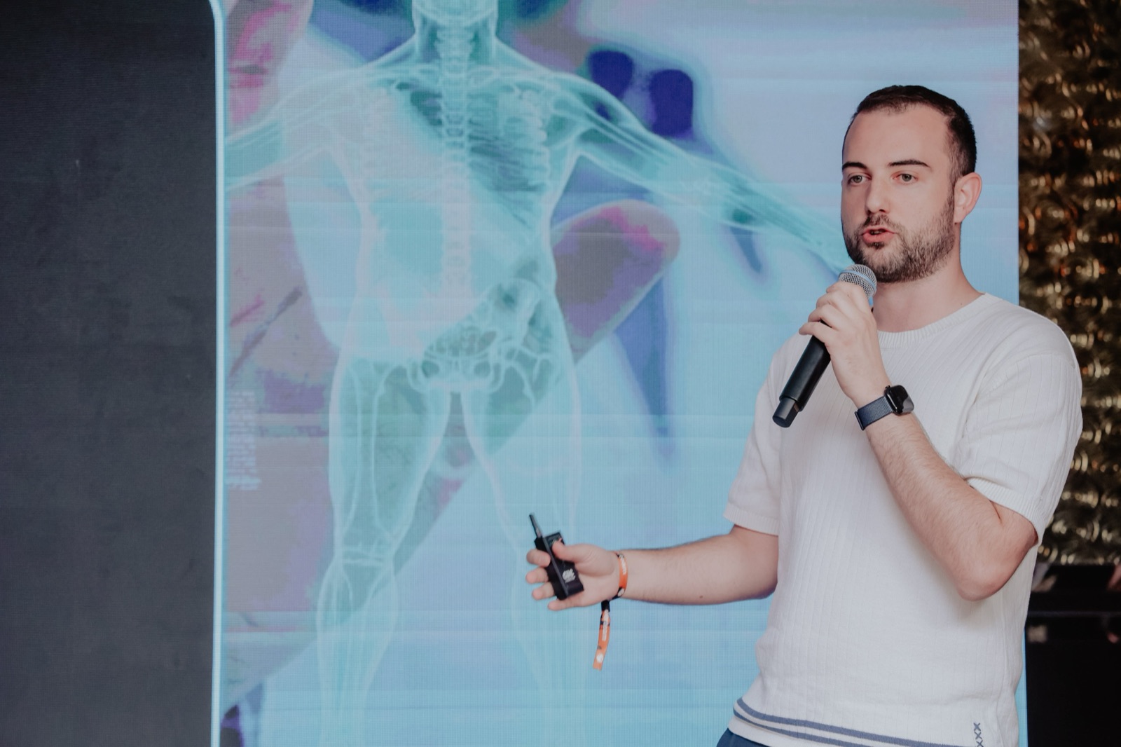 Dr. Marino Šabijan presenting on stage in front of a healthcare visual display.